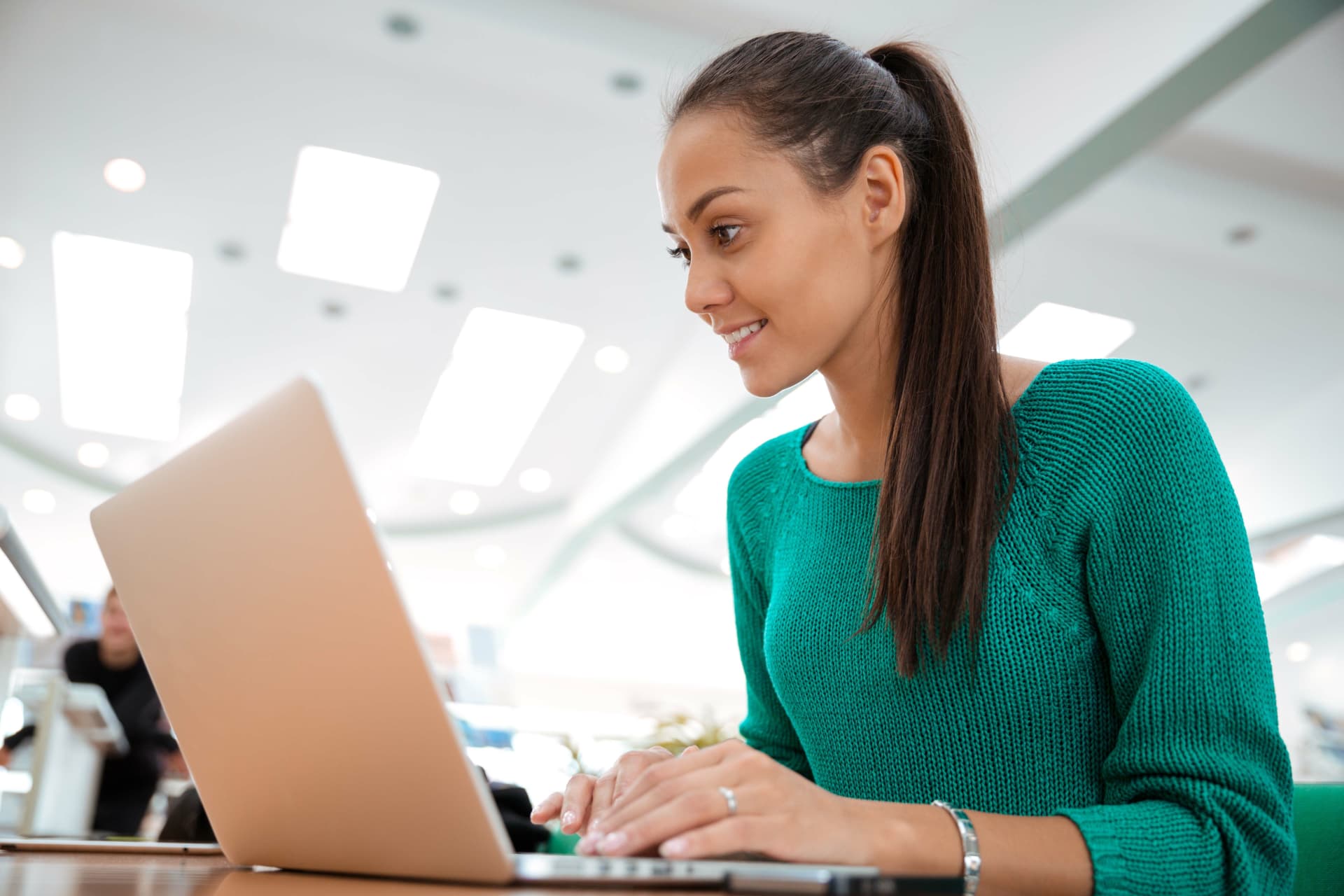 A woman working on a laptop in a bright office